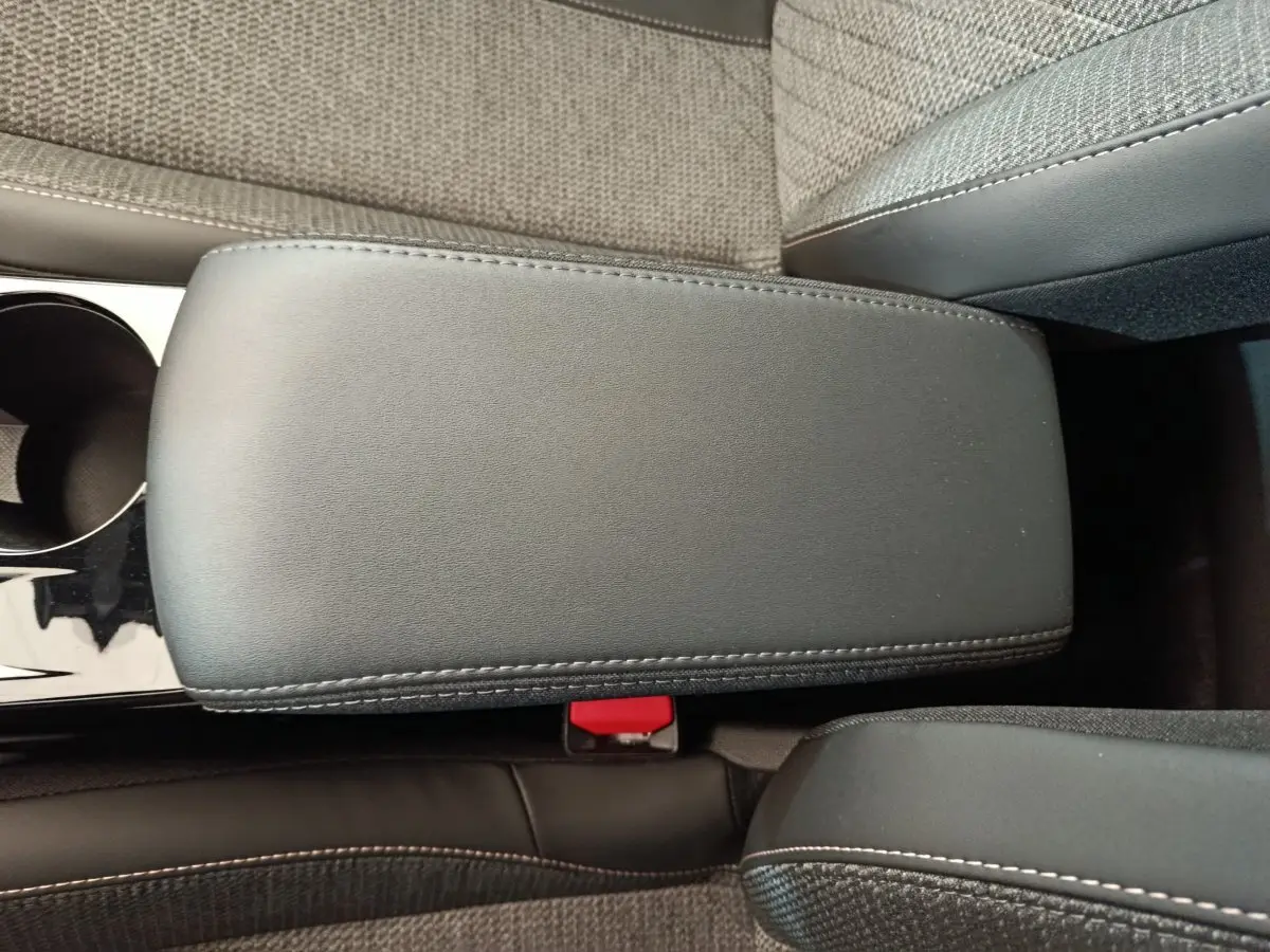 Accoudoir central avant en cuir noir avec surpiqûres, sièges tissu gris clair Peugeot 208 PureTech 2025.