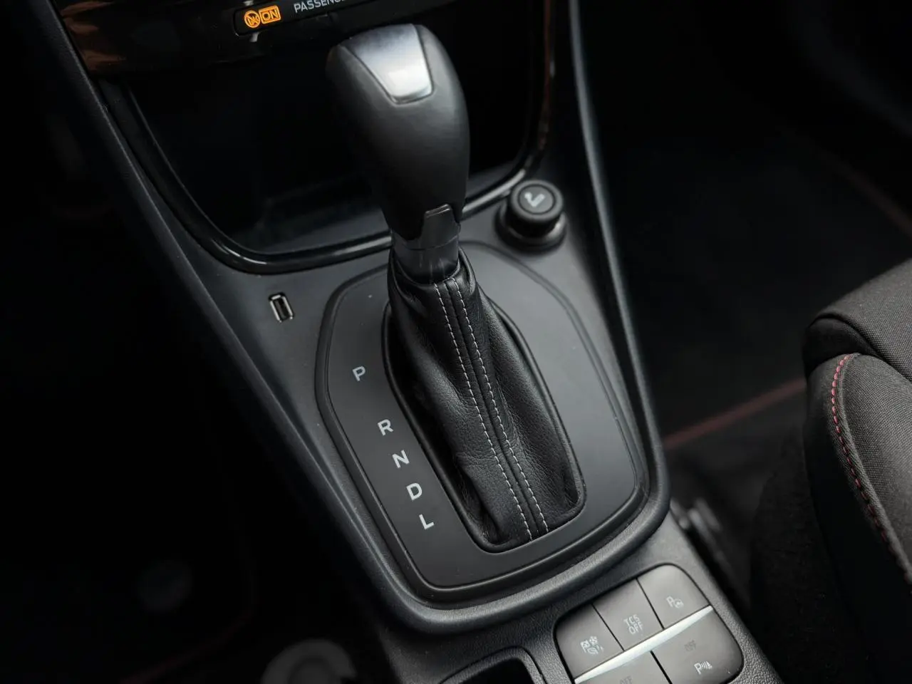 Gros plan sur la console centrale du Ford Puma gris magnétique, mettant en valeur le levier de vitesses automatique et les boutons de contrôle.