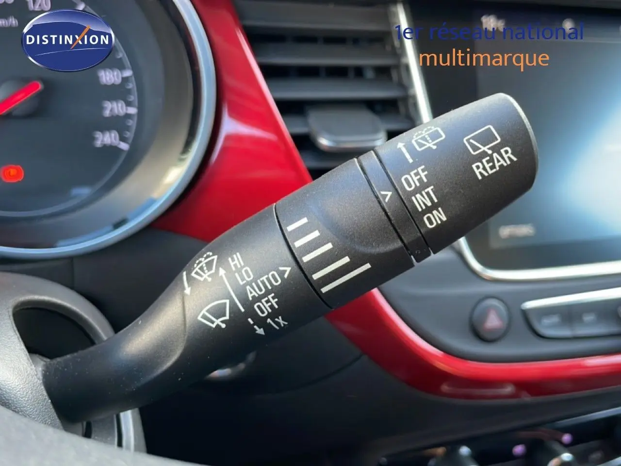 Gros plan sur la commande d’essuie-glace dans l’habitacle rouge noir de l’Opel Crossland 2023 essence.