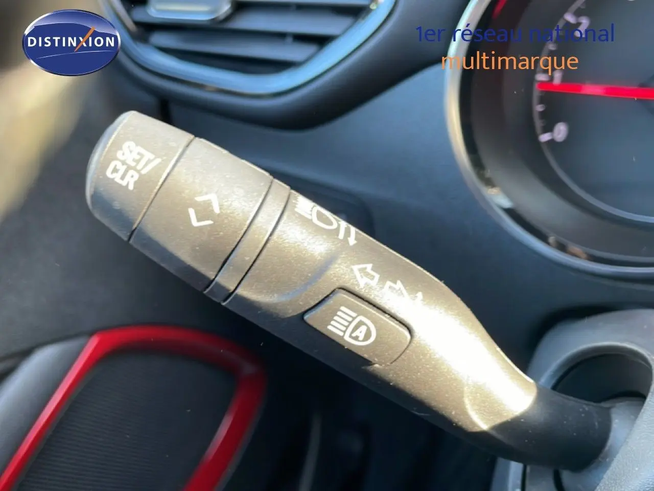 Gros plan sur la manette de commande des phares et clignotants dans l’habitacle d’un Opel Crossland noir Karbon 2023.