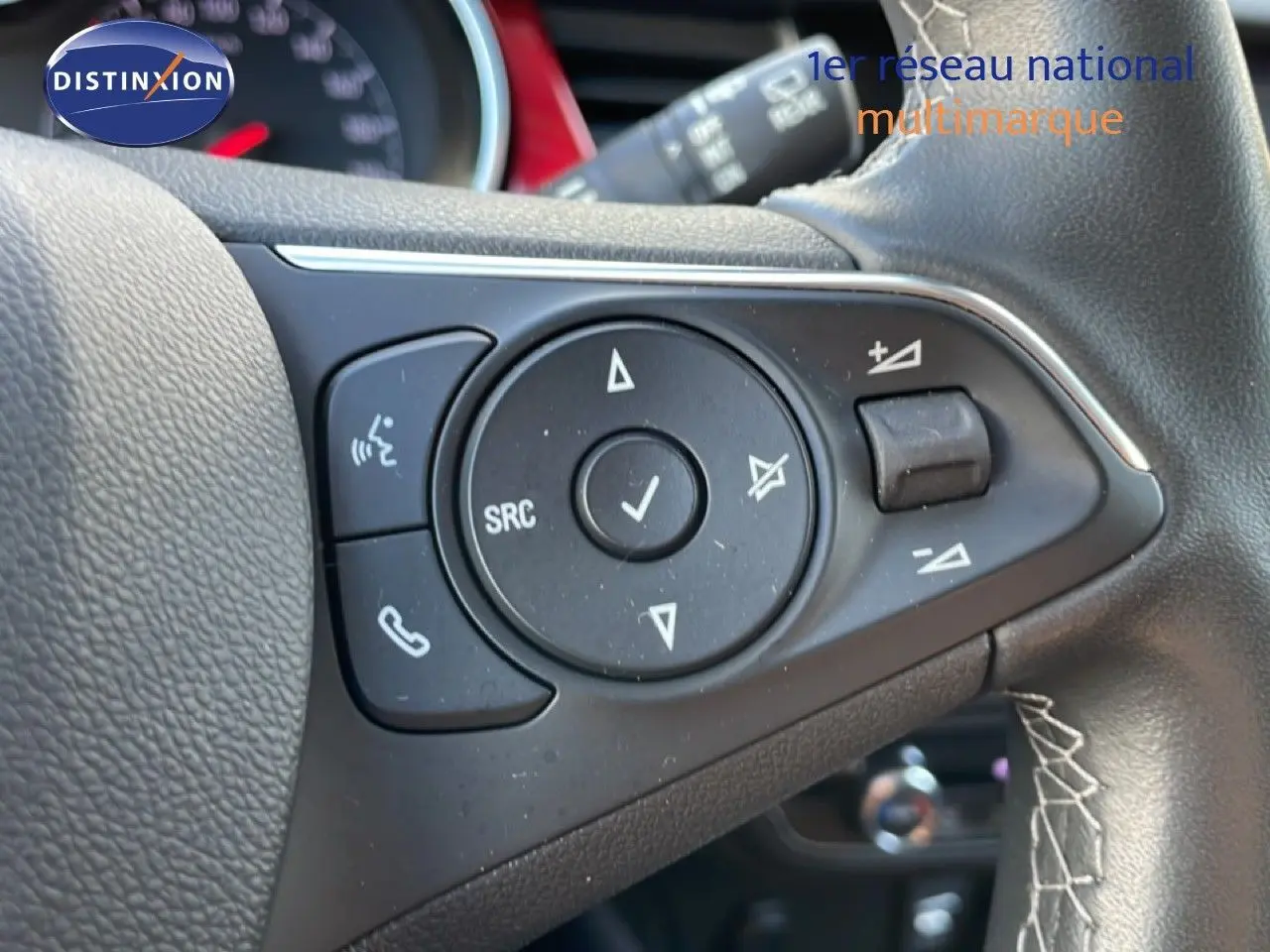 Gros plan sur les commandes du volant côté gauche de l’Opel Crossland noir Karbon 2023, avec boutons de réglage audio et téléphone.