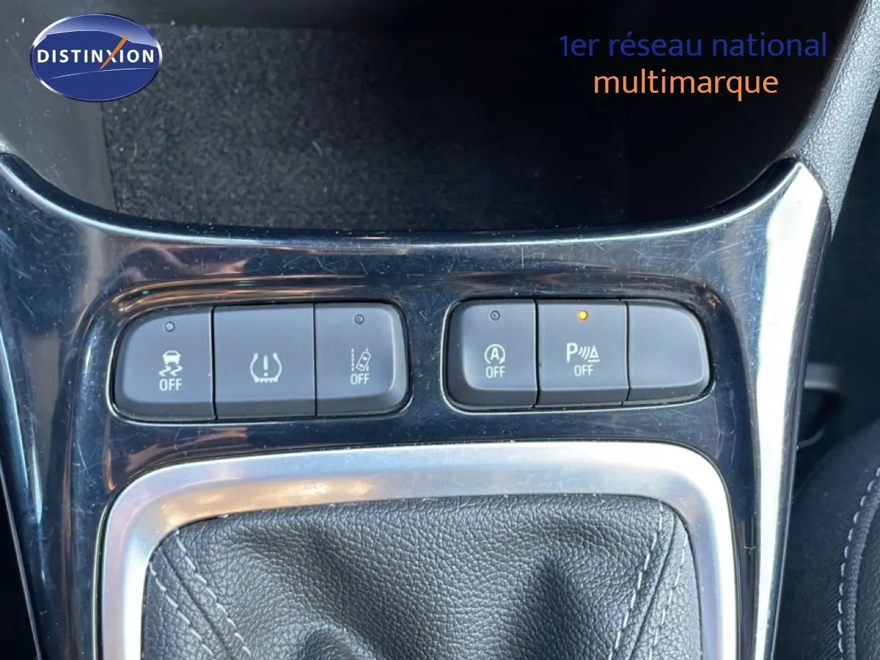 Gros plan sur la console centrale de l’Opel Crossland 2023 noir Karbon, montrant les boutons de contrôle autour du levier de vitesse.