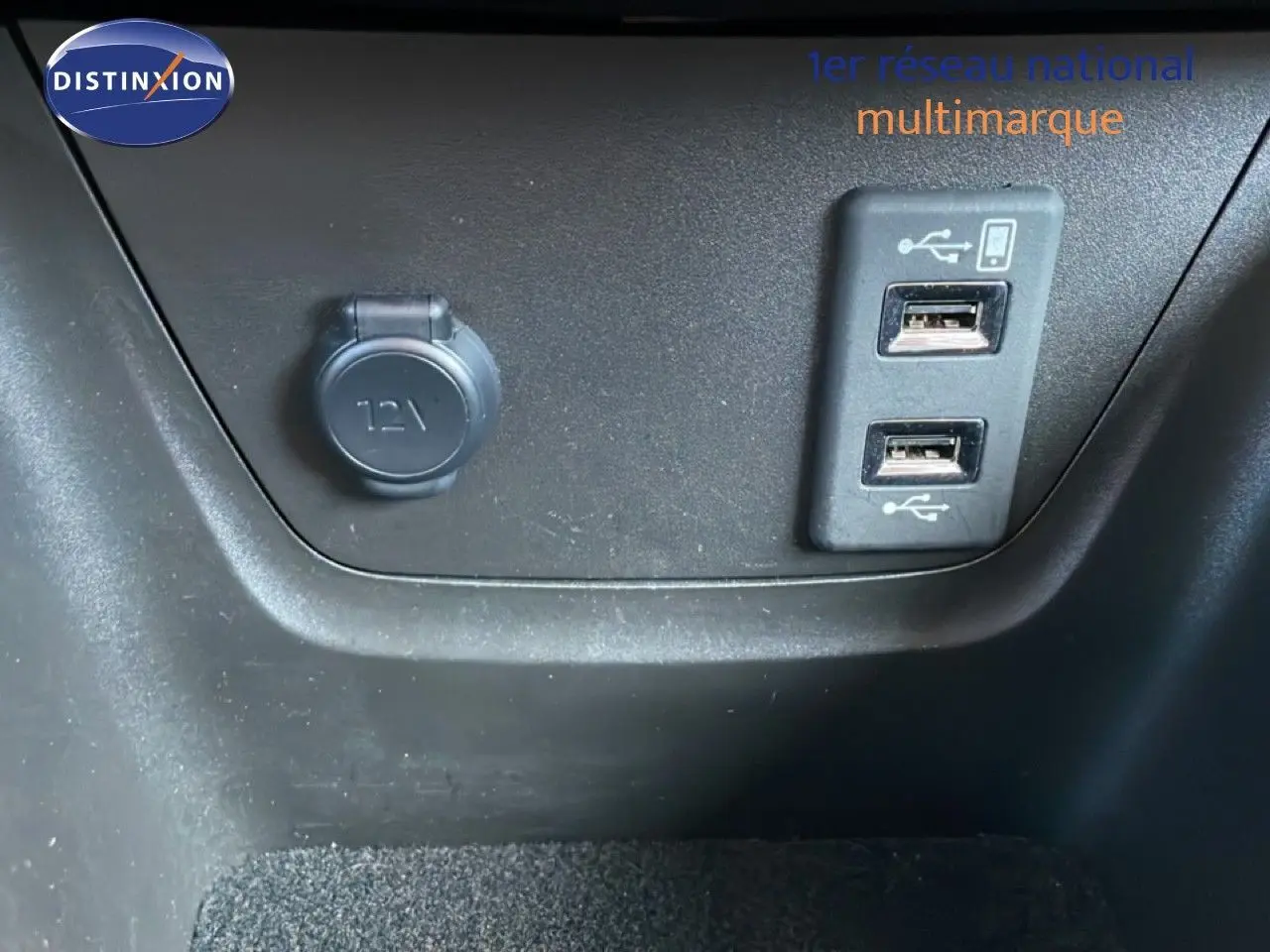 Gros plan sur la prise 12V et les deux ports USB intégrés dans l’habitacle de l’Opel Crossland noir Karbon 2023.