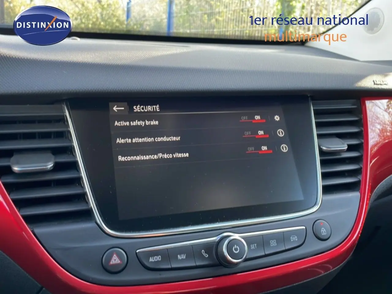 Vue rapprochée de l’écran central tactile et tableau de bord rouge brillant de l’Opel Crossland 2023.