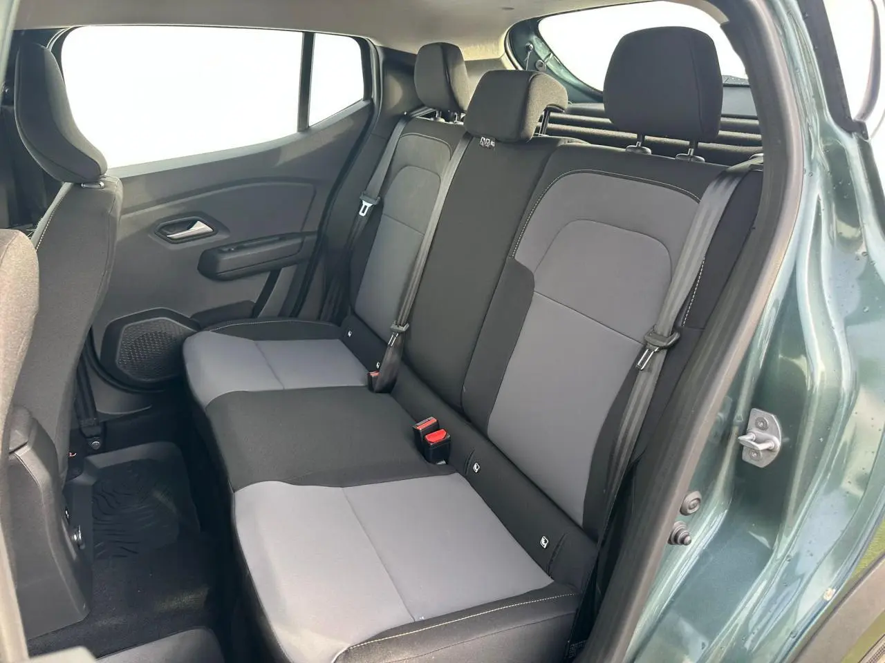 Vue intérieure arrière côté droit de la banquette grise et noire du Dacia Sandero III Stepway Vert Cèdre 2025.