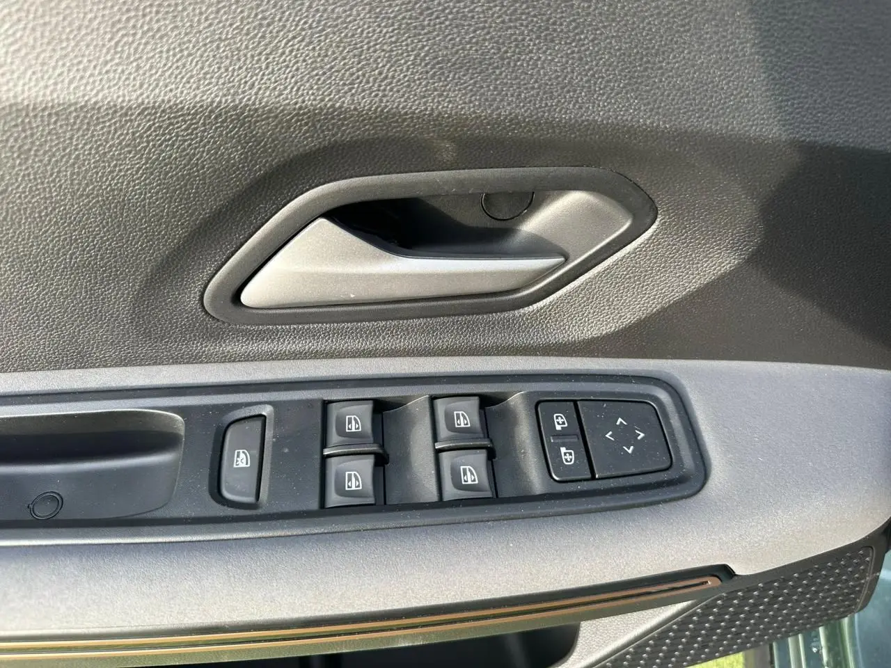 Gros plan sur la commande des vitres électriques côté conducteur de la Dacia Sandero III Stepway Vert Cèdre.
