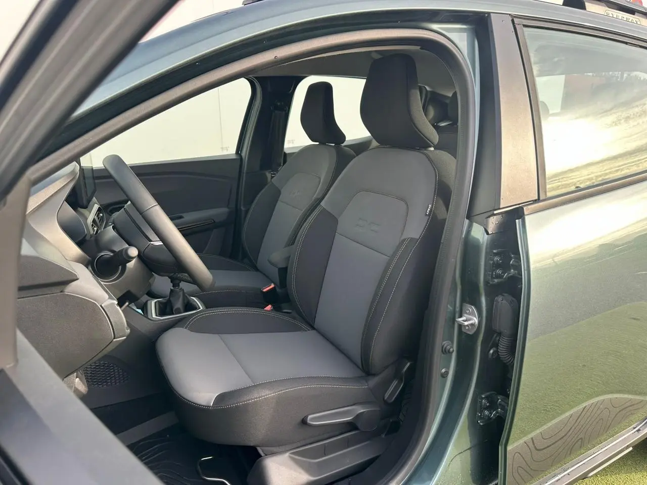 Vue côté gauche intérieur de la Dacia Sandero III Stepway 2025 vert cèdre, montrant les sièges avant et le volant.