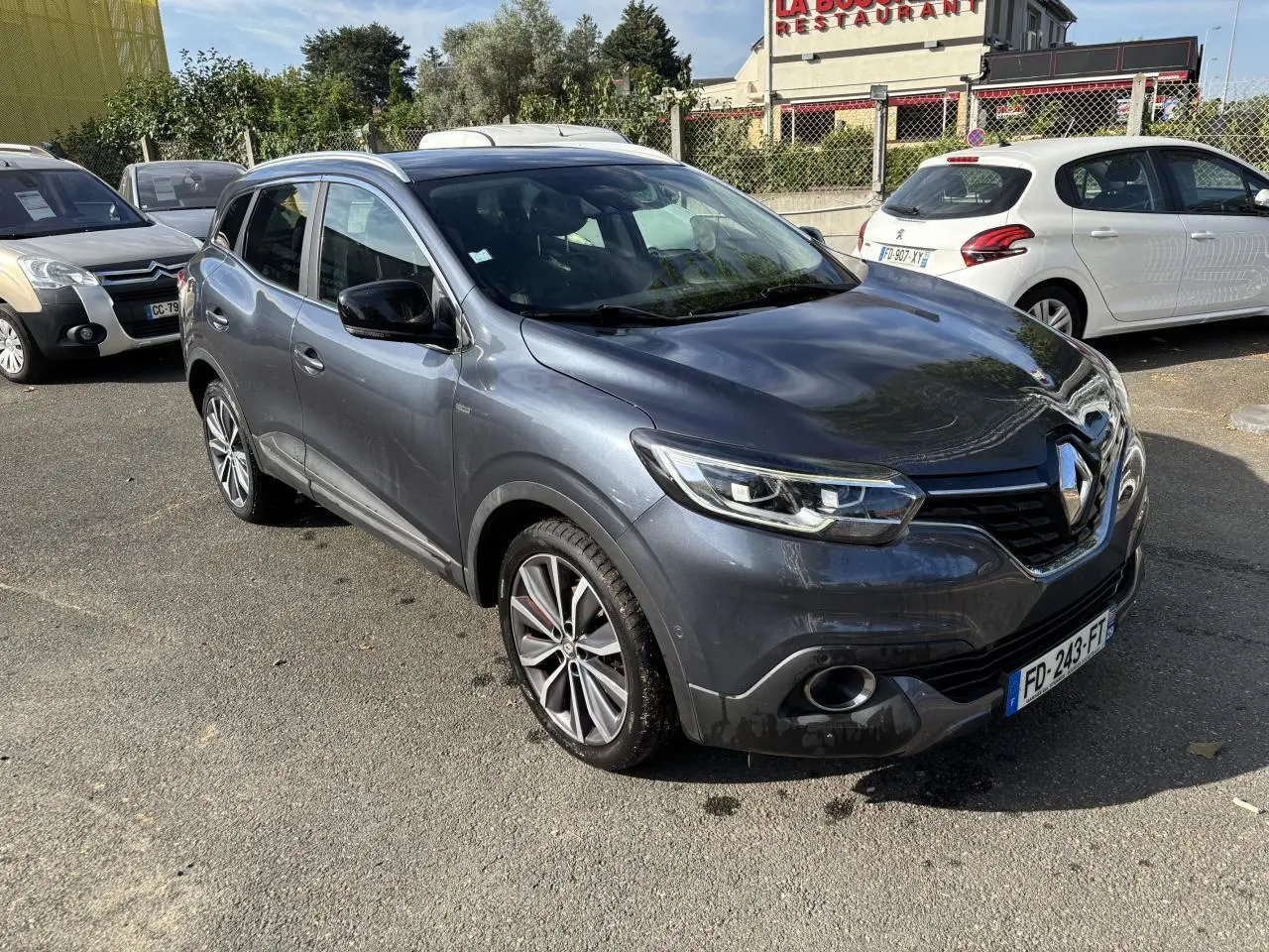 Renault Kadjar gris foncé en 3/4 avant droit, avec projecteurs Full LED et jantes alliage visibles.