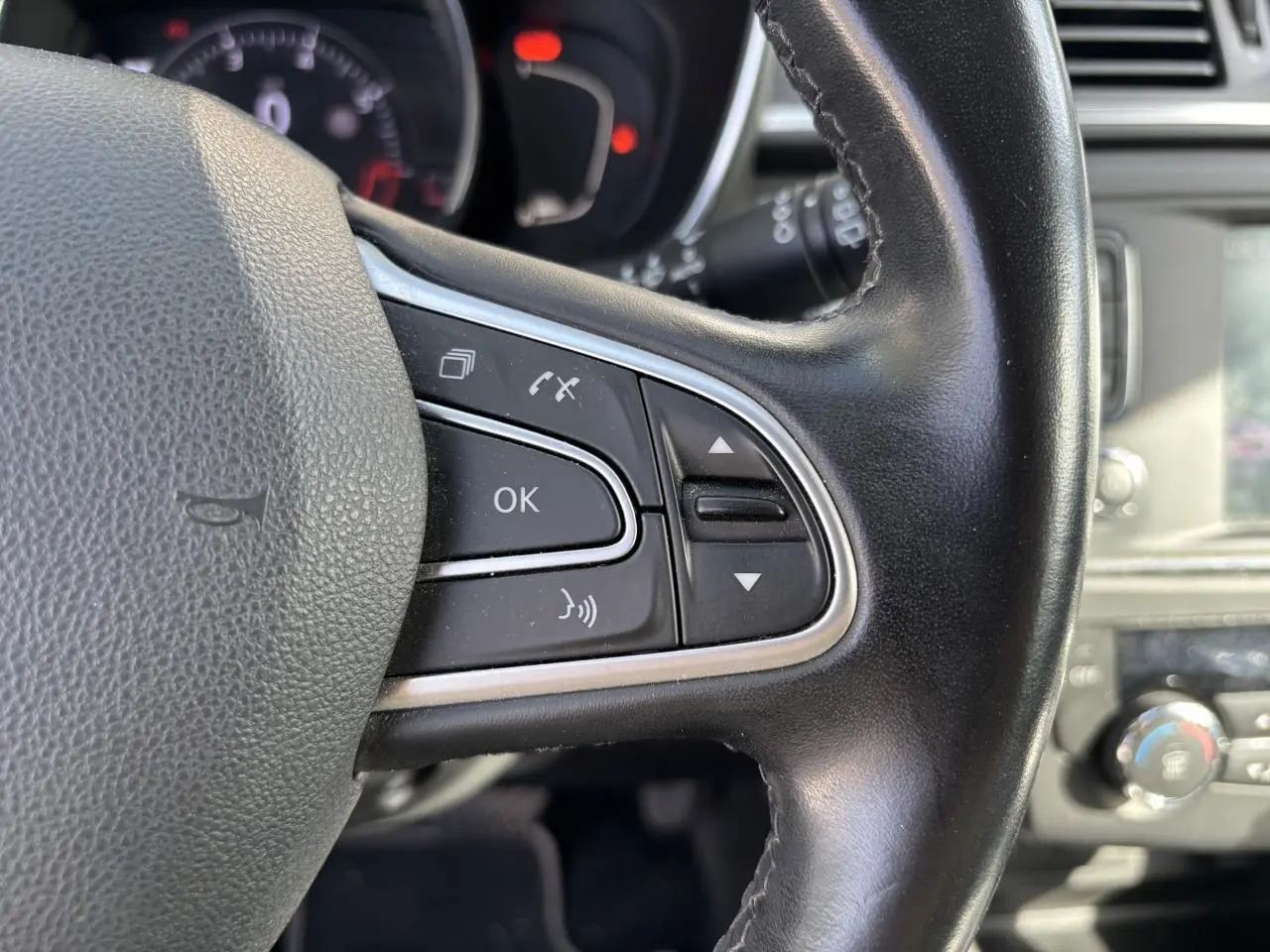 Gros plan sur le volant cuir Nappa du Renault Kadjar 2018, avec commandes intégrées et tableau de bord en arrière-plan.