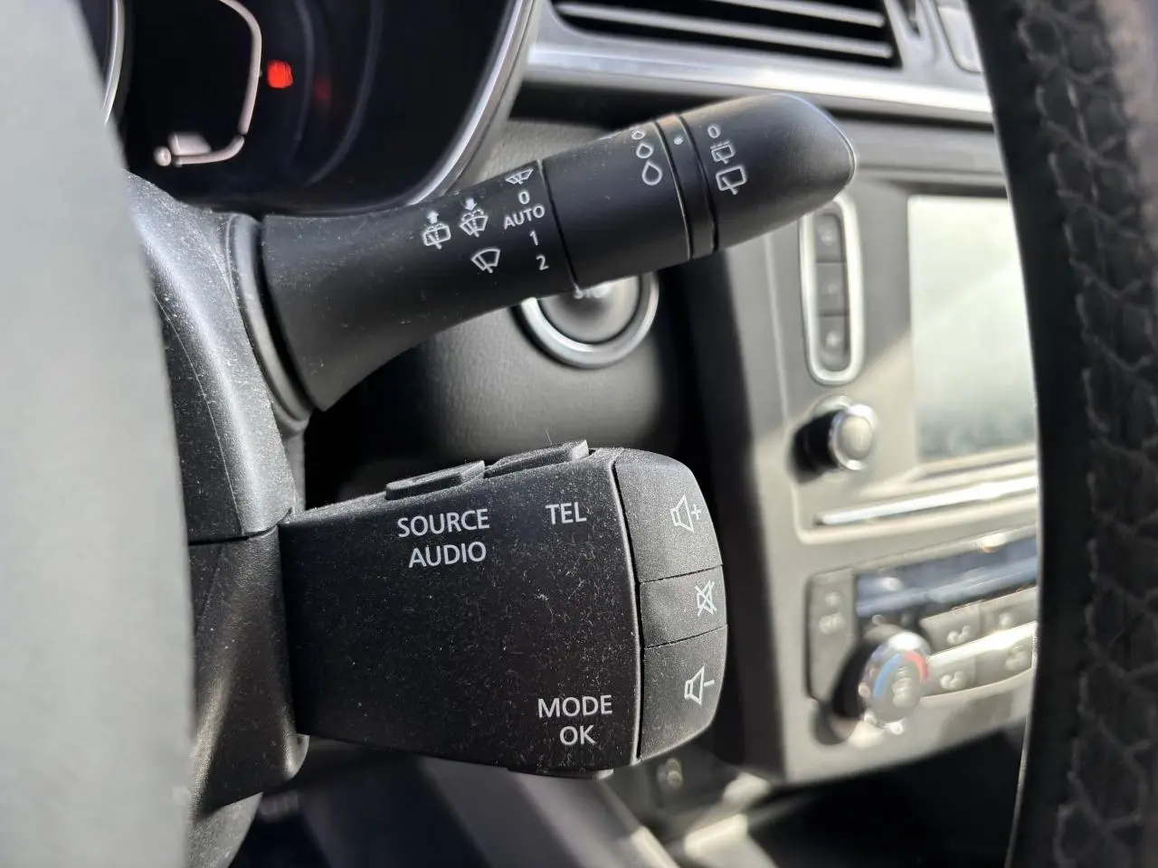 Gros plan sur la commande audio au volant du Renault Kadjar 2018, intérieur noir avec tableau de bord visible en arrière-plan.