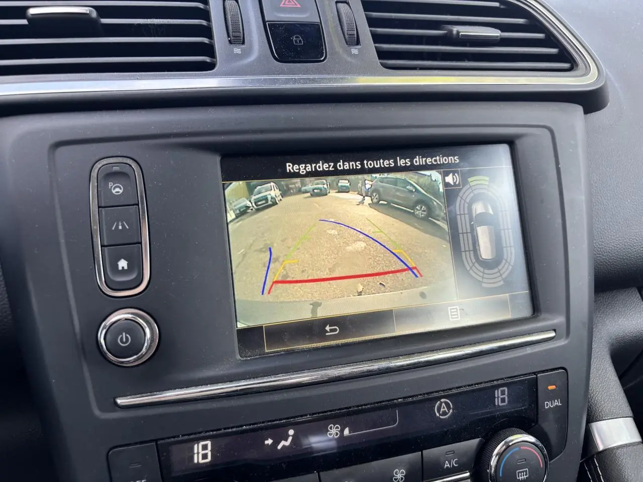 Vue rapprochée de l’écran central du Renault Kadjar gris foncé 2018 montrant la caméra de recul et la climatisation automatique bi-zone.