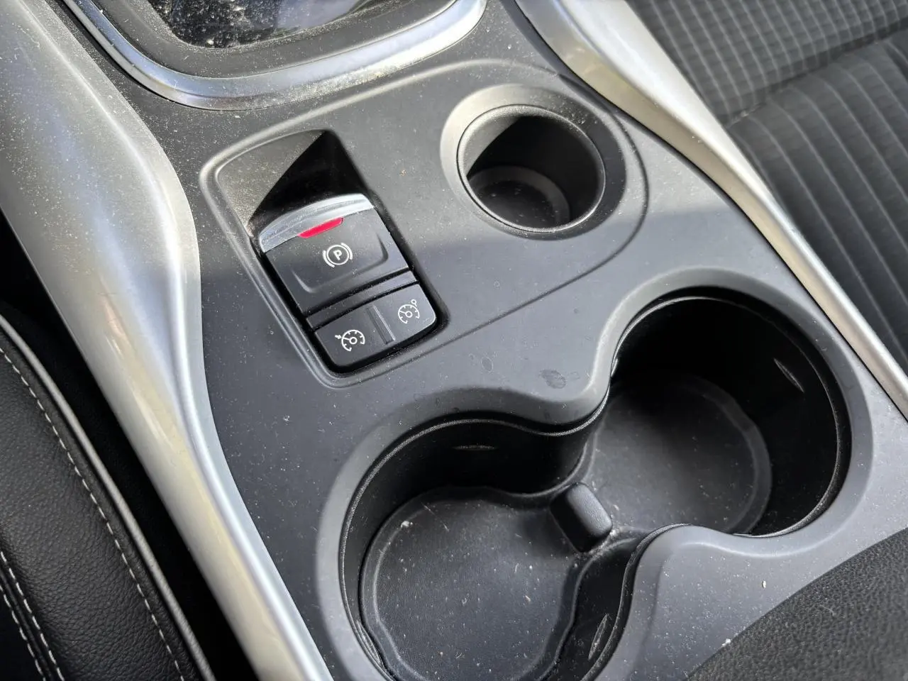 Gros plan sur la console centrale noire du Renault Kadjar 2018, avec frein de parking électrique et porte-gobelets.
