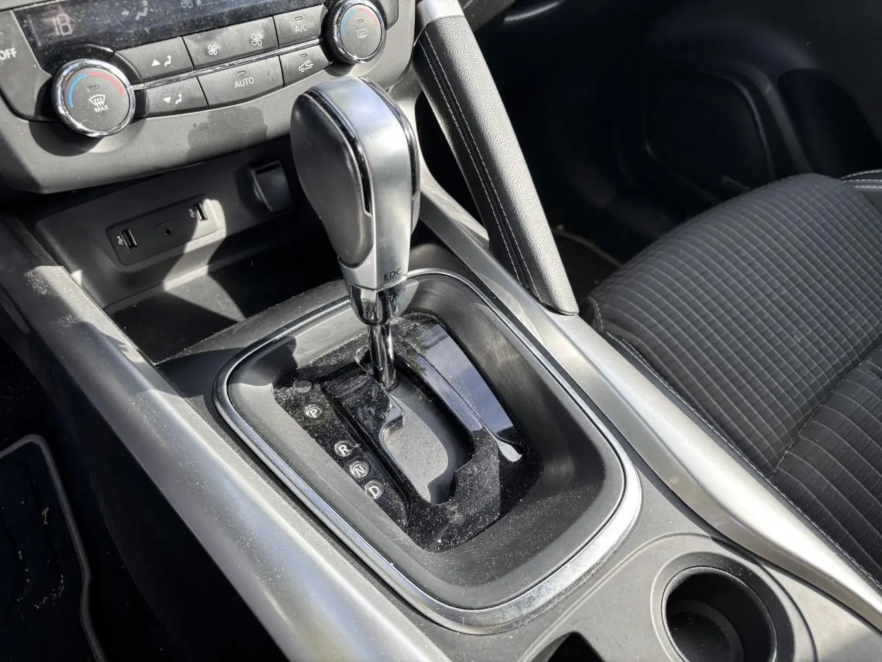 Gros plan sur la console centrale du Renault Kadjar 2018 avec levier de boîte auto EDC et sièges tissu gris foncé.