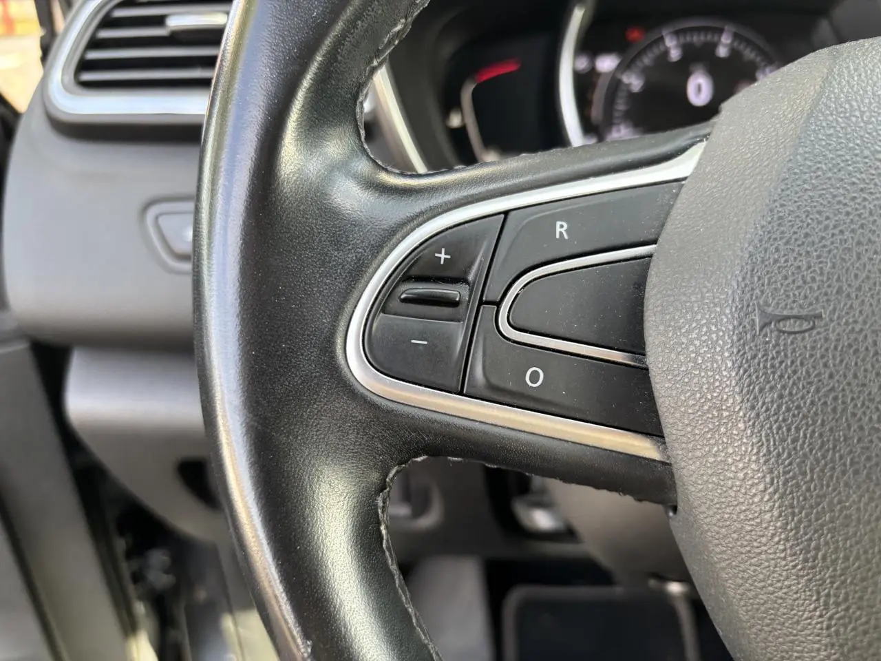 Gros plan sur le volant cuir noir du Renault Kadjar 2018 avec commandes intégrées et tableau de bord en arrière-plan.