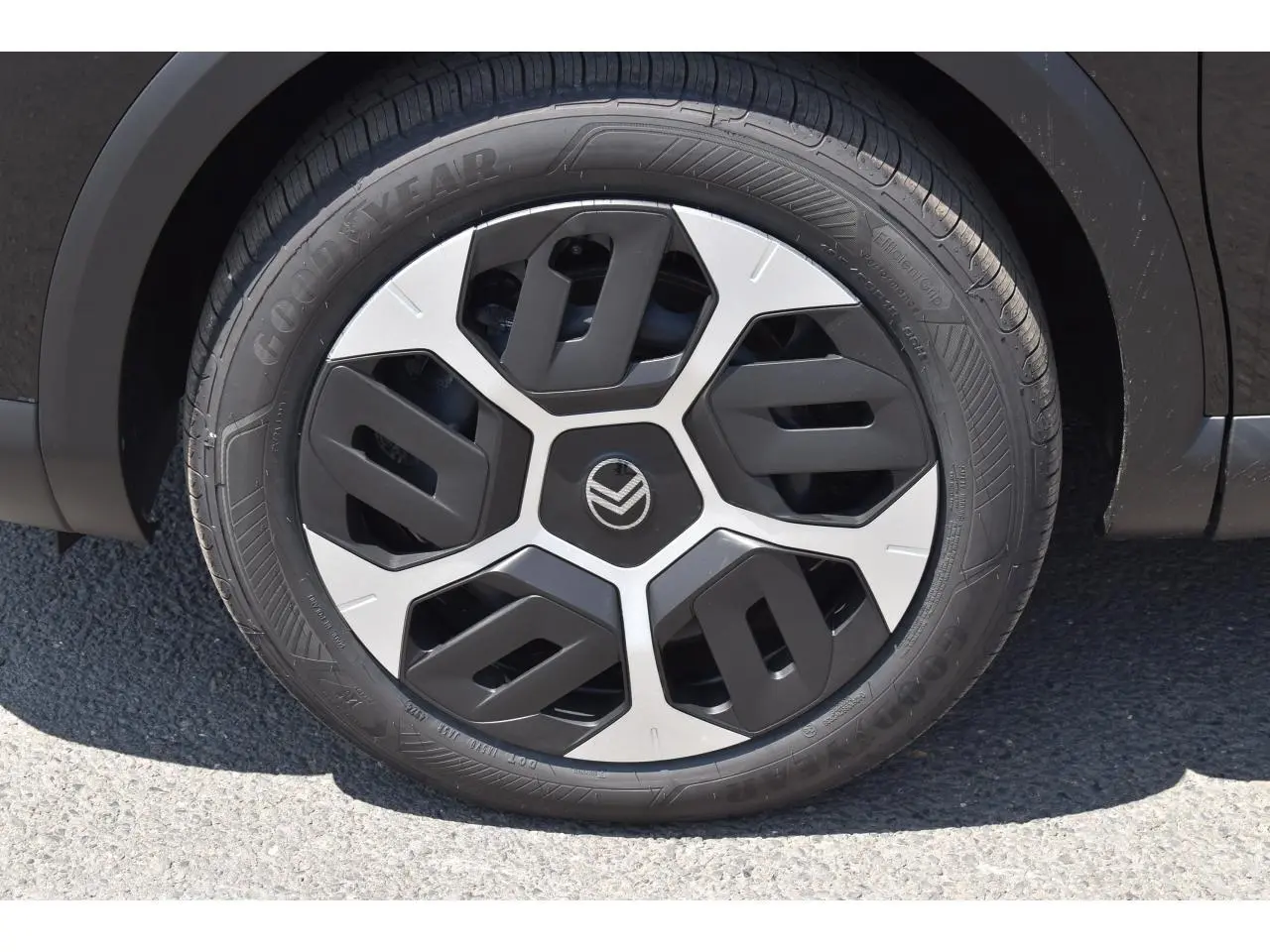 Gros plan sur la roue avant droite noire d'une Citroën C4 Hybride 2025 avec enjoliveur 18 pouces AEROTECH bicolore.