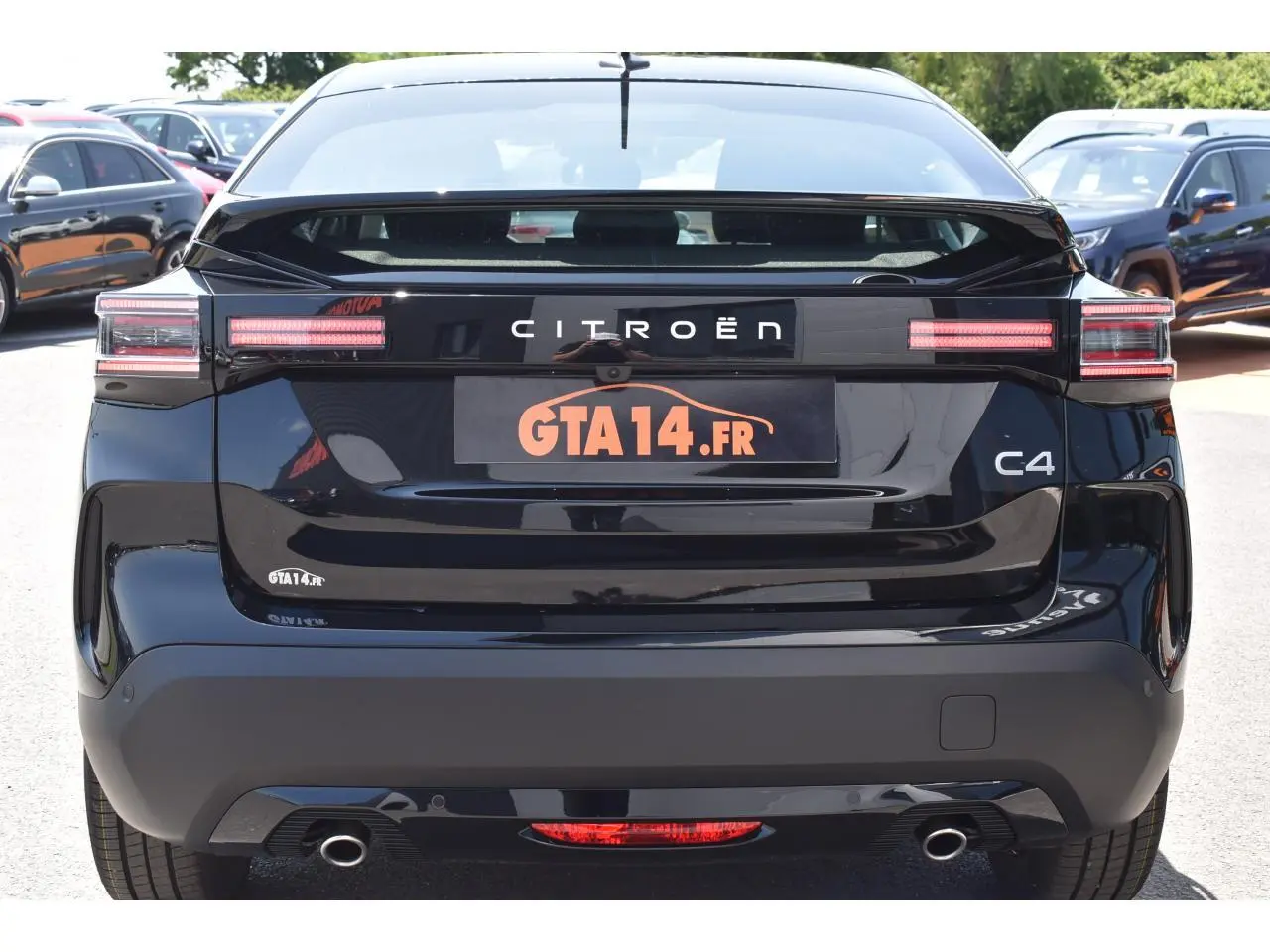 Vue arrière d'une Citroën C4 noire 2025 avec feux LED et double sortie d'échappement visible en stationnement.