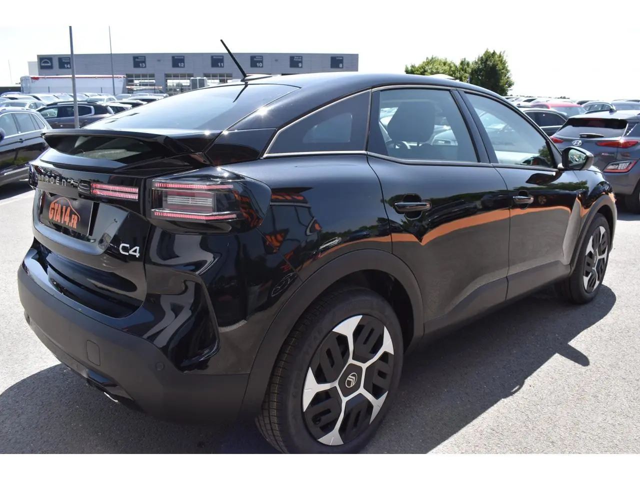 Vue 3/4 arrière droite d'une Citroën C4 Hybride noire 2025 avec feux LED et jantes Aerotech 18 pouces.