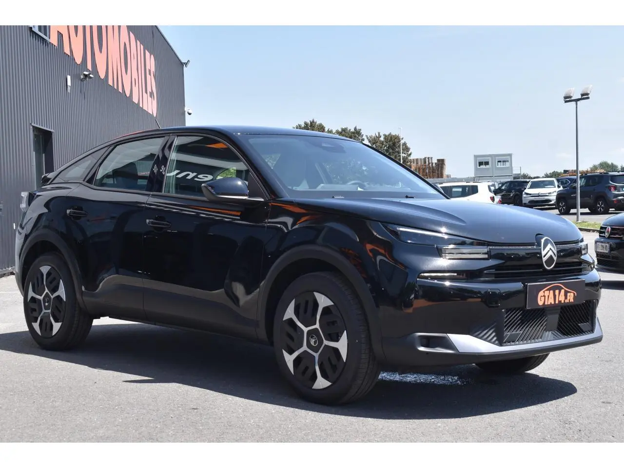 Vue 3/4 avant gauche d'une Citroën C4 Hybride 2025 noire avec enjoliveurs 18 pouces et feux LED distinctifs.