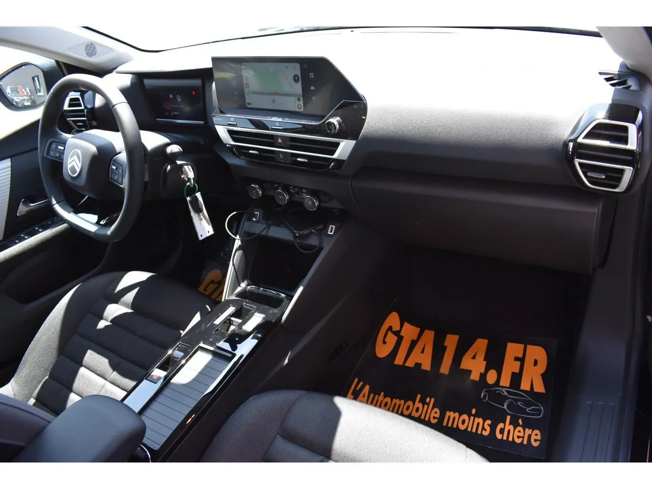 Vue intérieure côté conducteur de la Citroën C4 Hybride 2025 avec tableau de bord noir et écran tactile central 10 pouces.