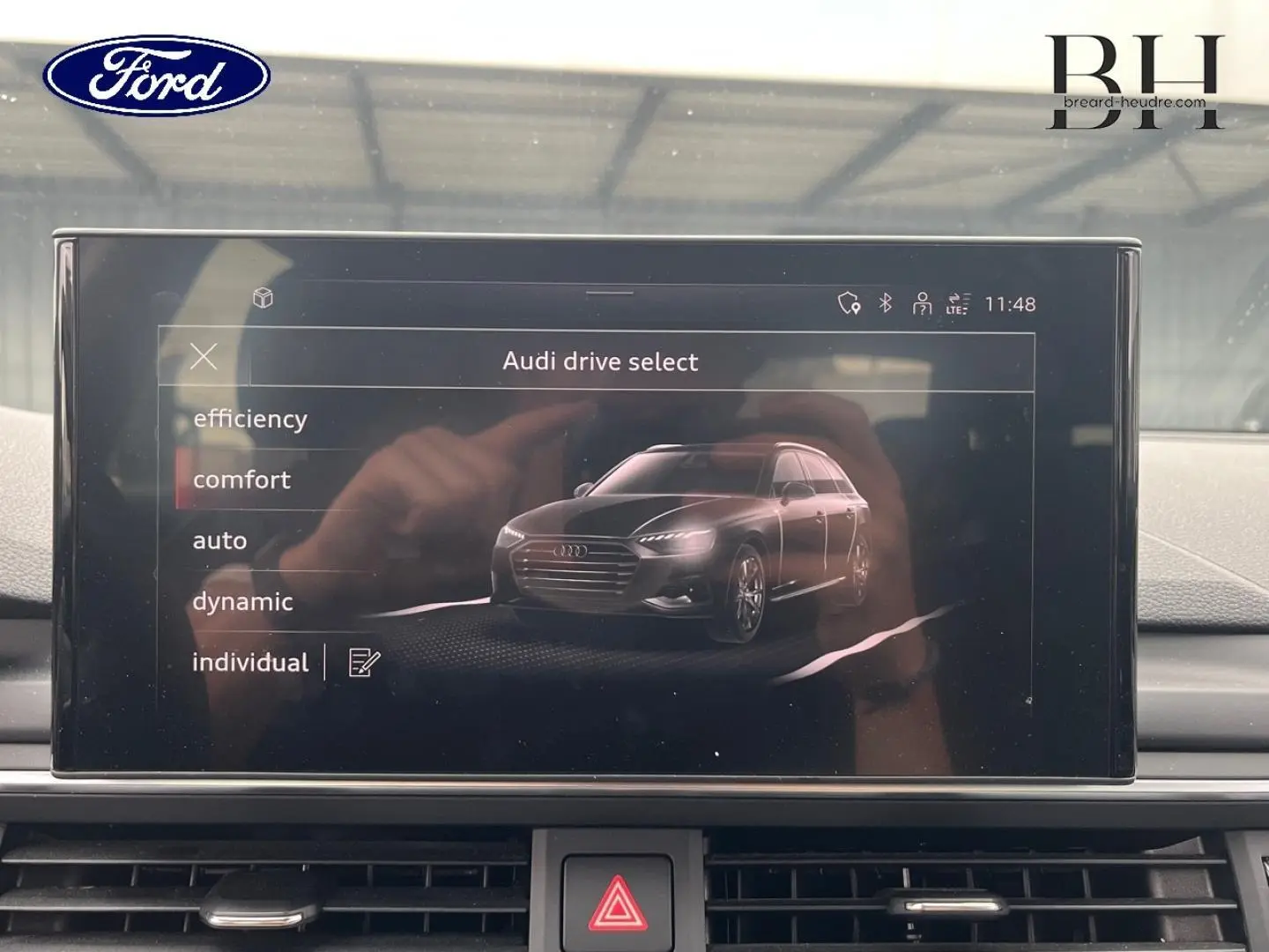 Écran central intérieur montrant le menu Audi drive select avec une illustration 3D d'une Audi A4 Avant.