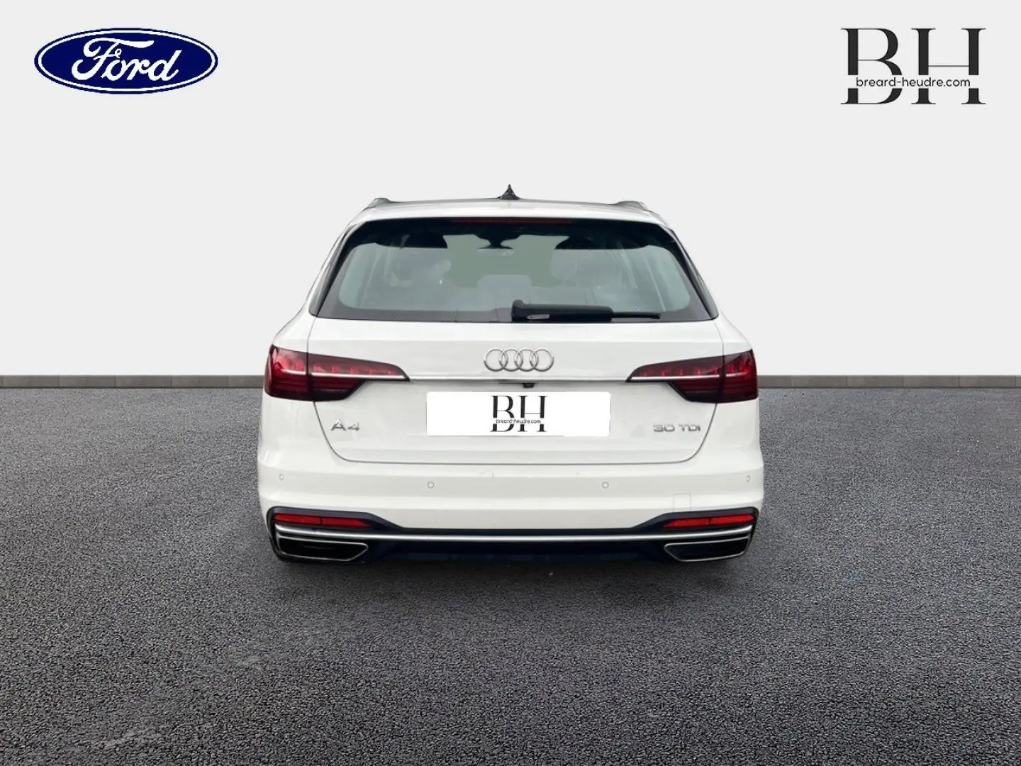 Vue arrière d'une Audi A4 Avant blanc glacier métallisé avec feux arrière LED et double sortie d'échappement chromée.