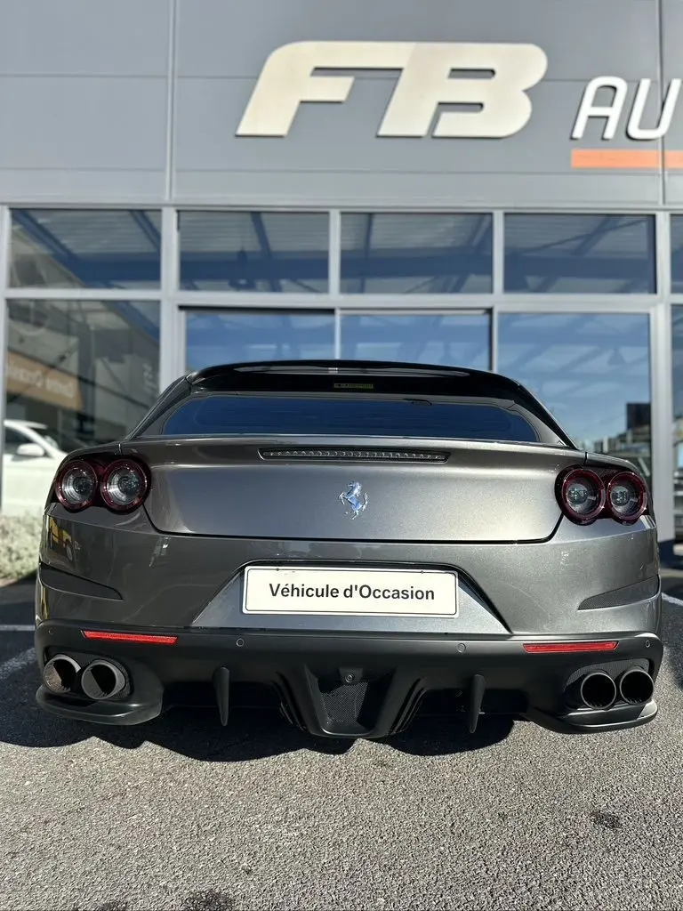 Vue arrière d'une Ferrari GTC4 Lusso gris foncé de 2017 avec double sortie d'échappement et logo au centre.