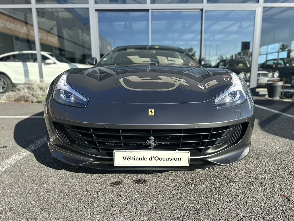 Vue frontale d'une Ferrari GTC4 Lusso gris foncé 2017 avec calandre noire et logo cheval cabré au centre.