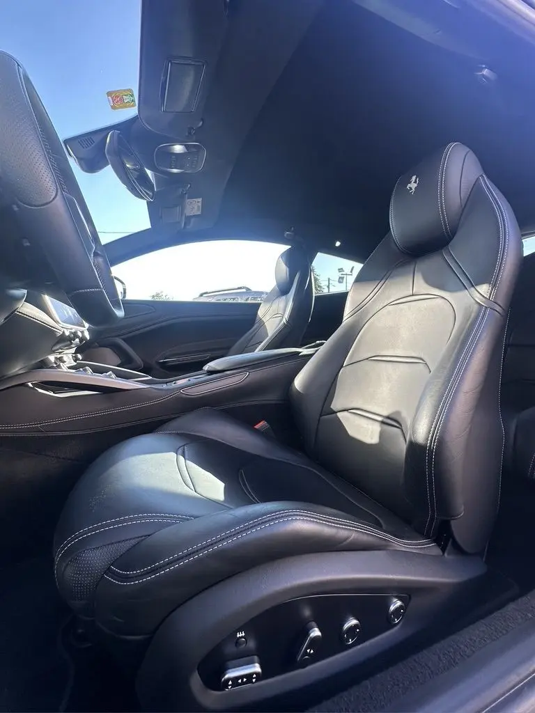 Intérieur cuir noir avec surpiqûres blanches de la Ferrari GTC4 Lusso 2017, vue côté conducteur en lumière naturelle.
