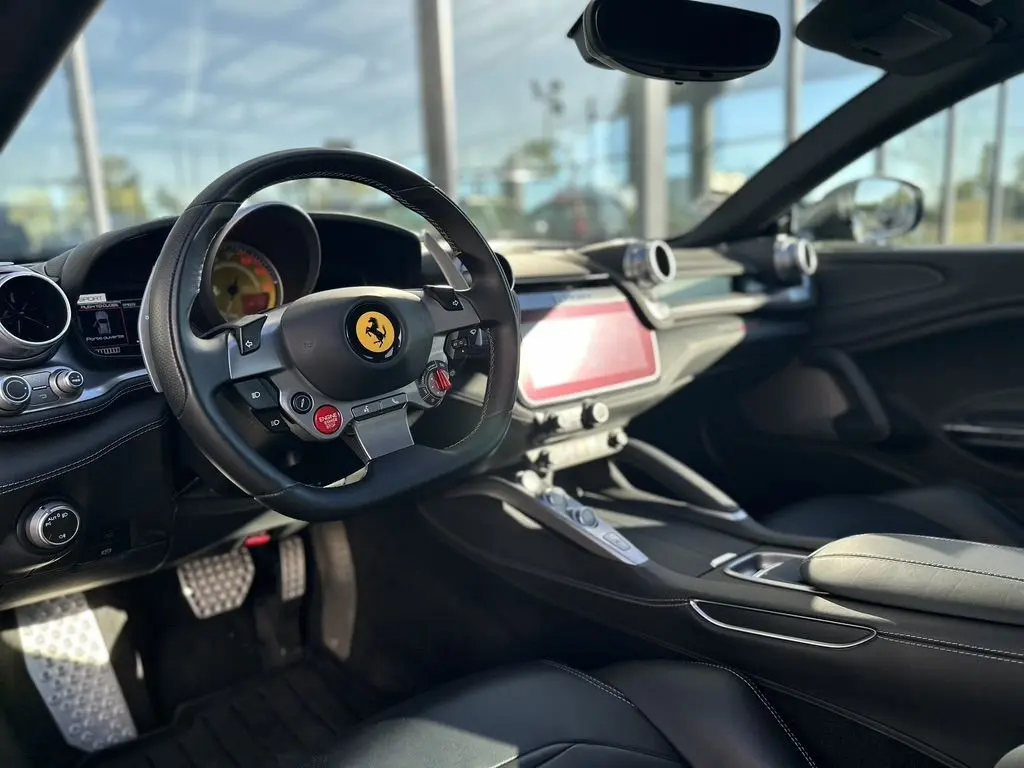 Intérieur de la Ferrari GTC4 Lusso 2017 en gris foncé, vue côté conducteur sur le volant avec logo cheval cabré.