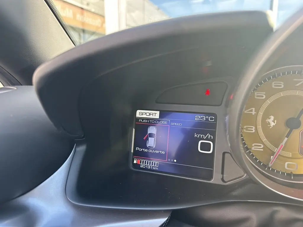 Tableau de bord de Ferrari GTC4 Lusso 2017 avec écran digital indiquant porte ouverte et compte-tours jaune visible.