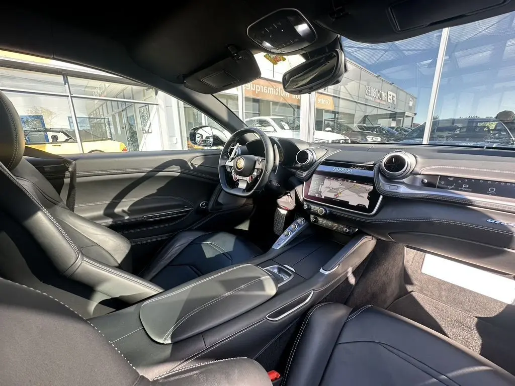 Intérieur noir cuir de la Ferrari GTC4 Lusso 2017 vu côté conducteur, avec tableau de bord et écran tactile.