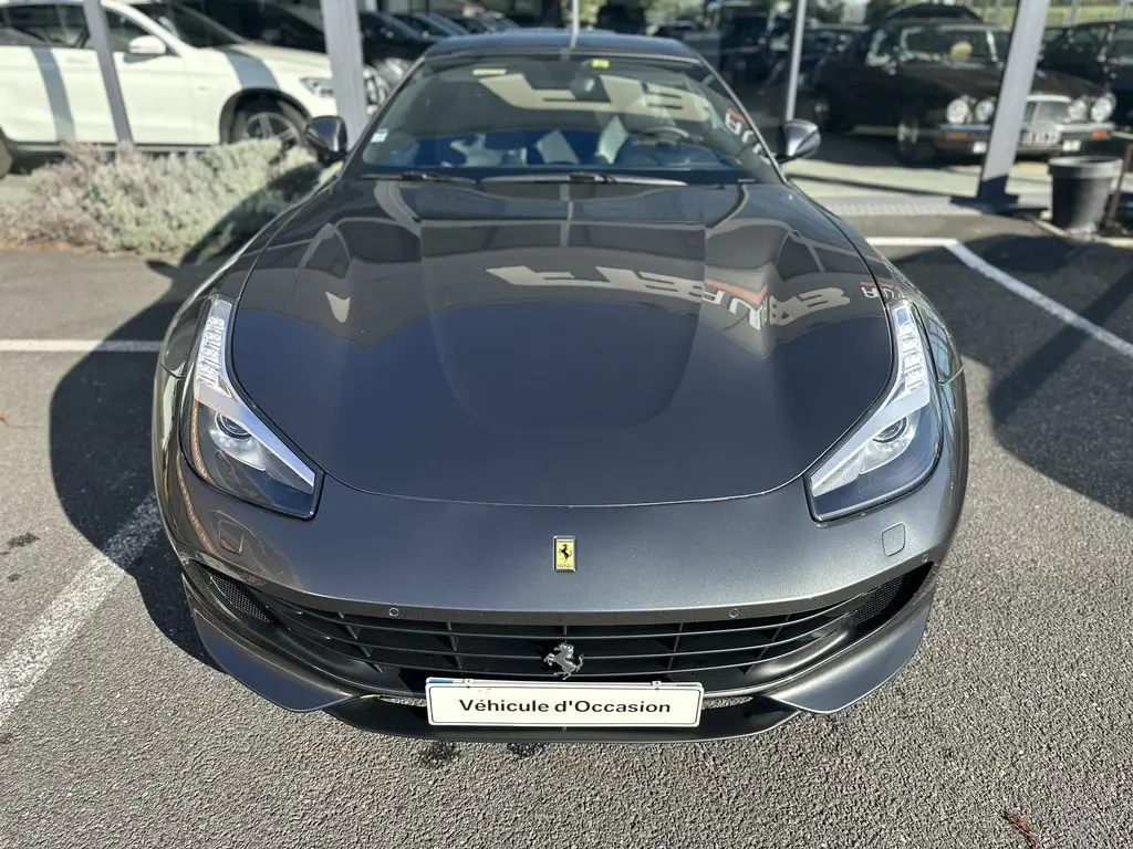 Vue avant plongeante d'une Ferrari GTC4 Lusso gris foncé avec ses phares LED distinctifs et calandre noire.
