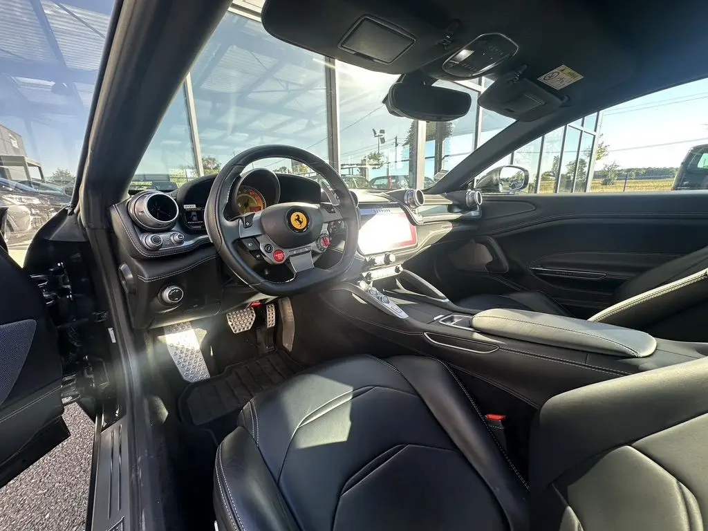 Intérieur noir de la Ferrari GTC4 Lusso 2017 vu côté conducteur, avec volant sport et tableau de bord moderne.