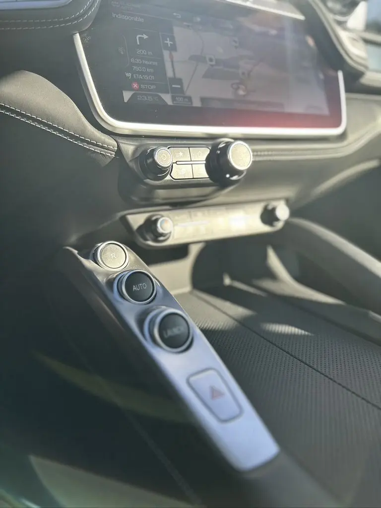 Détail de la console centrale de la Ferrari GTC4 Lusso gris foncé de 2017, avec commandes de boîte automatique et écran tactile.