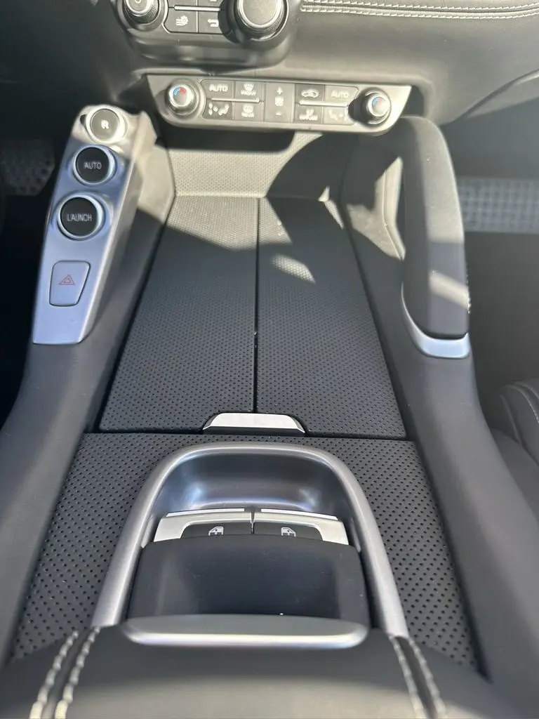 Gros plan sur la console centrale noire perforée de la Ferrari GTC4 Lusso 2017 avec boutons de commande et finition cuir.