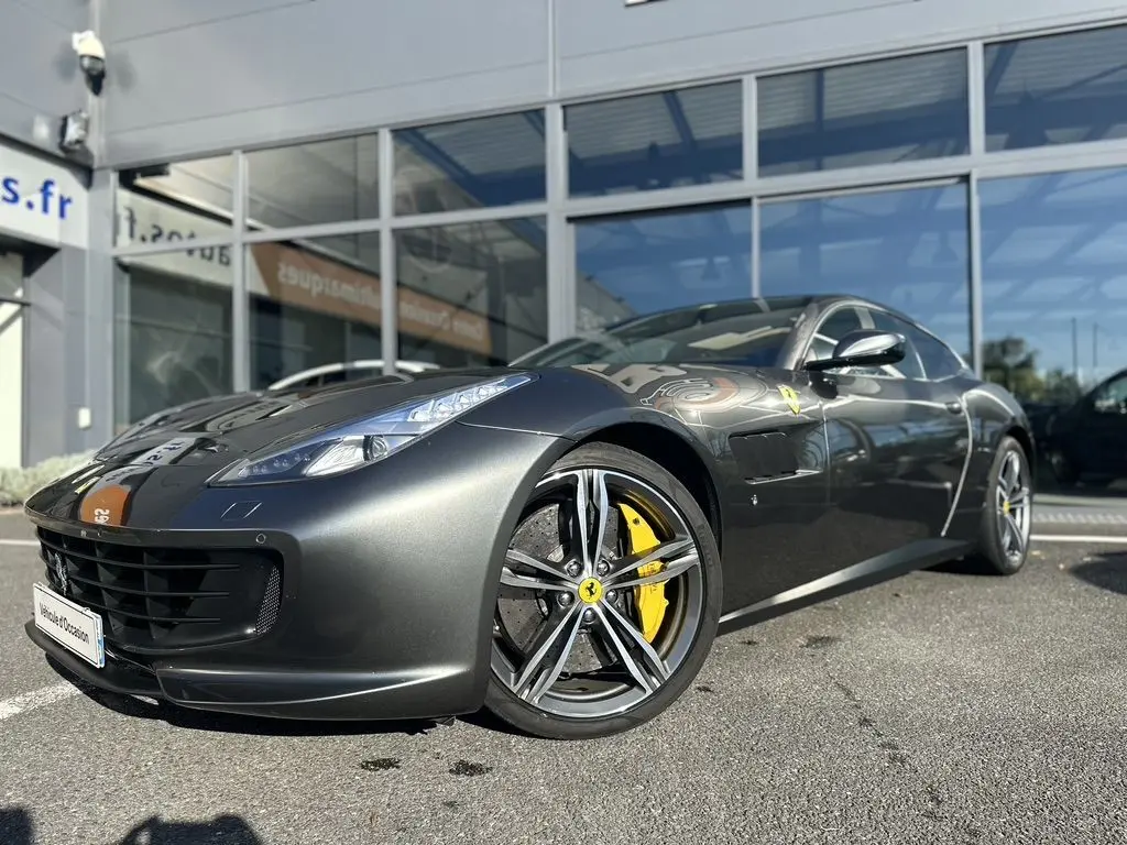 Ferrari GTC4 Lusso gris foncé vue 3/4 avant avec jantes alliage et étriers de frein jaunes visibles.