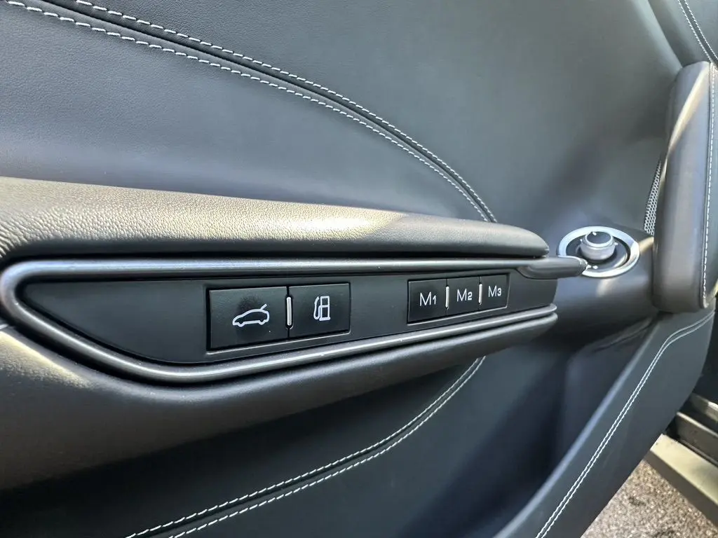 Gros plan sur la porte côté gauche de la Ferrari GTC4 Lusso 2017, cuir gris foncé avec boutons de réglages mémoire M1, M2, M3.