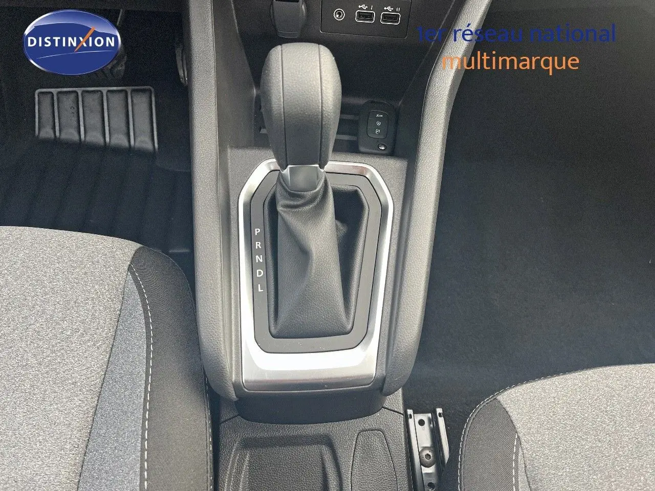 Le levier de vitesses automatique de la Renault Clio TCE 90CH X-TRONIC en gros plan, avec sellerie tissu gris.