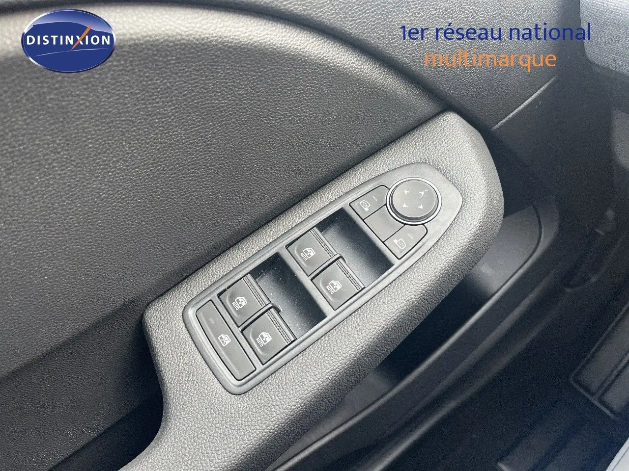 Gros plan sur les commandes de lève-vitres et rétroviseurs côté conducteur de la Renault Clio gris schiste 2024.