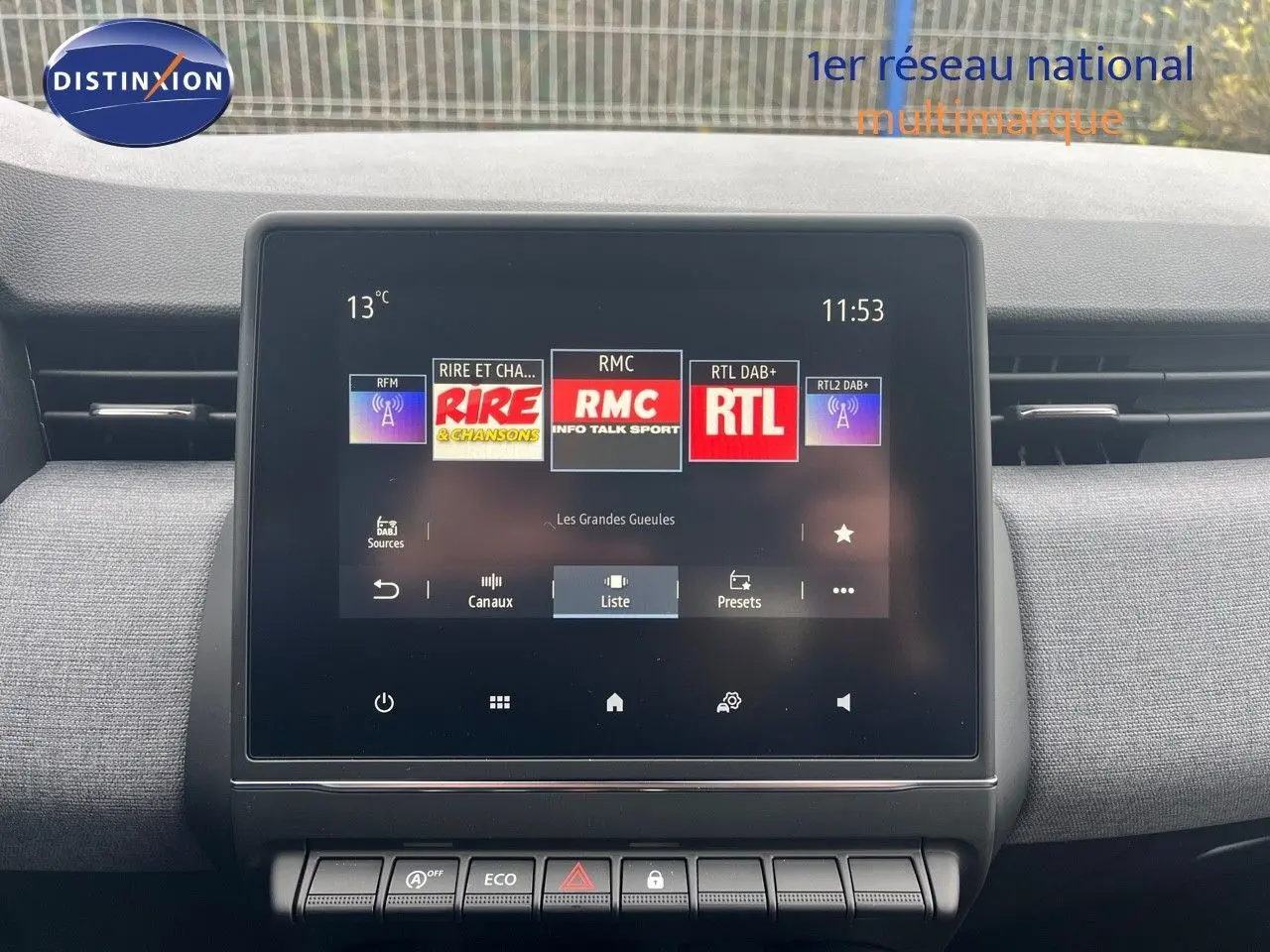Écran tactile central du tableau de bord de la Renault Clio gris schiste métal, affichant les stations radio numériques.