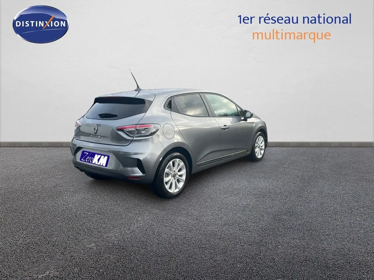 Renault Clio TCE 90CH X-TRONIC gris schiste métal vue 3/4 arrière côté droit sur sol bitumé.