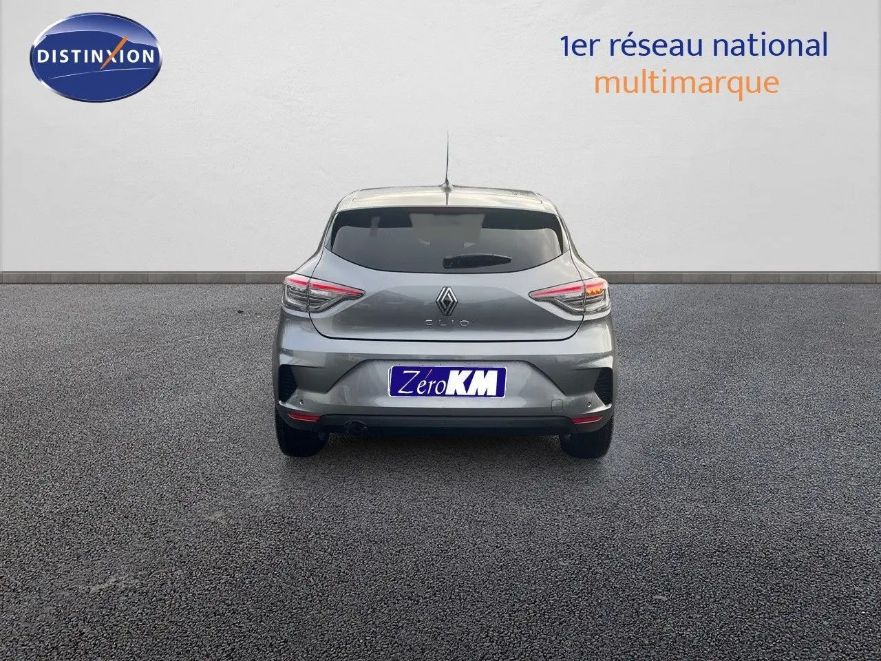 Vue arrière d'une Renault Clio 2024 gris schiste métal, avec feux LED et plaque d'immatriculation Zero KM visible.