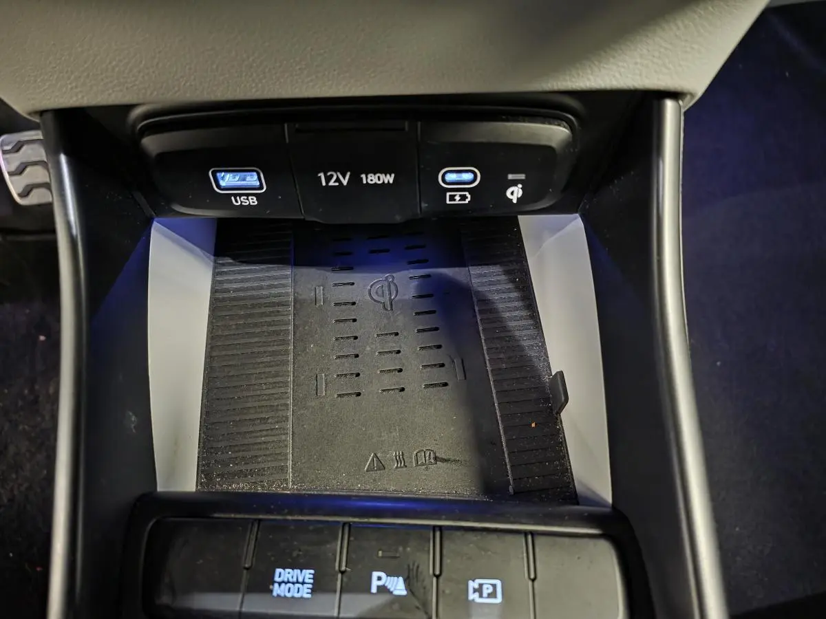 Gros plan sur la console centrale du Hyundai Bayon 2025 noire, montrant la recharge sans fil et ports USB éclairés.