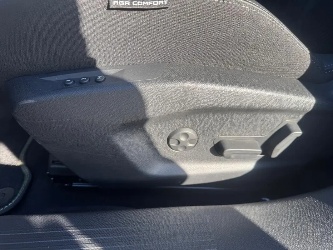 Vue rapprochée du côté gauche du siège conducteur gris avec commandes de réglage électrique et mémoire sur Peugeot 408 Hybrid 2024.