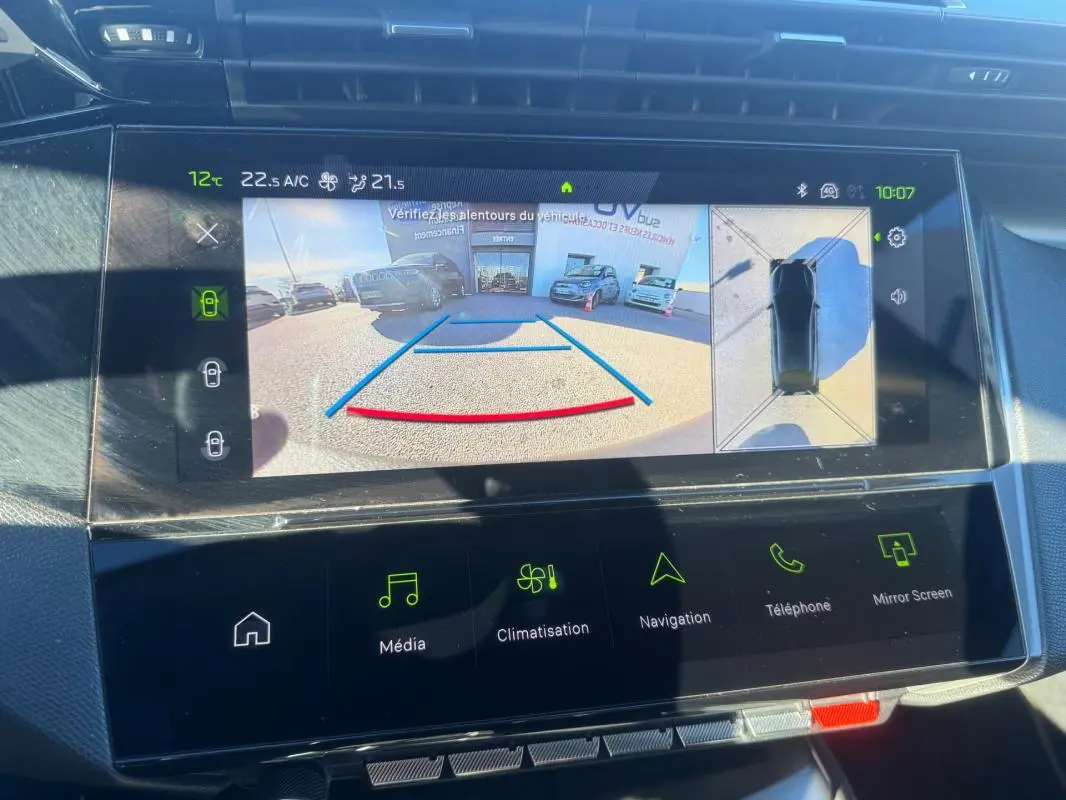 Écran central du tableau de bord montrant la caméra de recul et l'affichage 360° du Peugeot 408 Hybrid gris 2024.