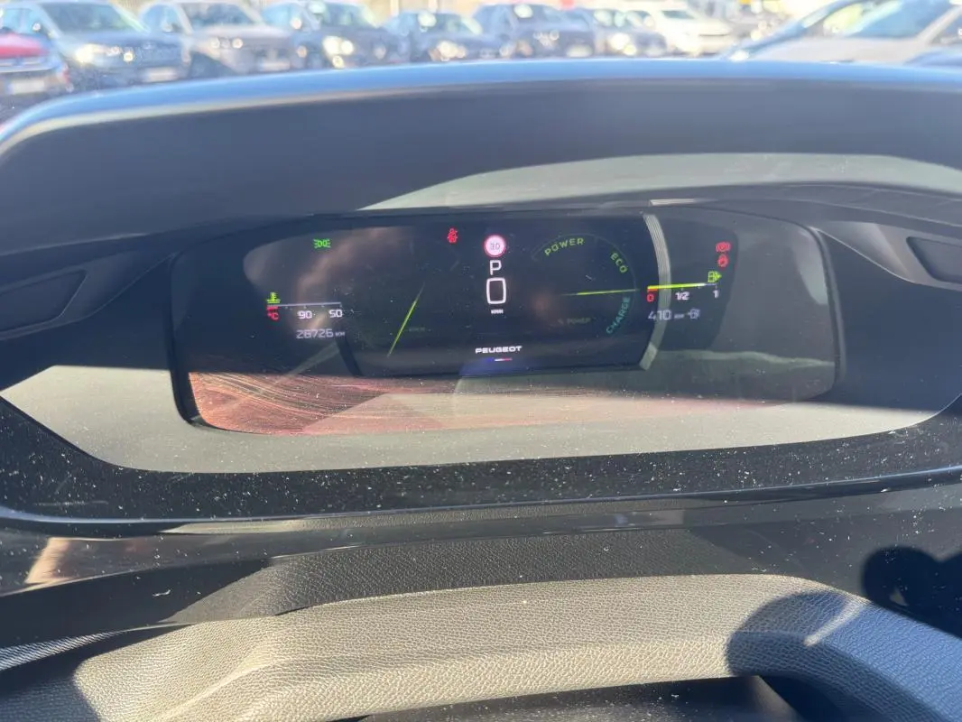 Vue rapprochée du cockpit numérique gris du Peugeot 408 Hybrid 136 e-DCS6 GT affichant la vitesse et l'autonomie.