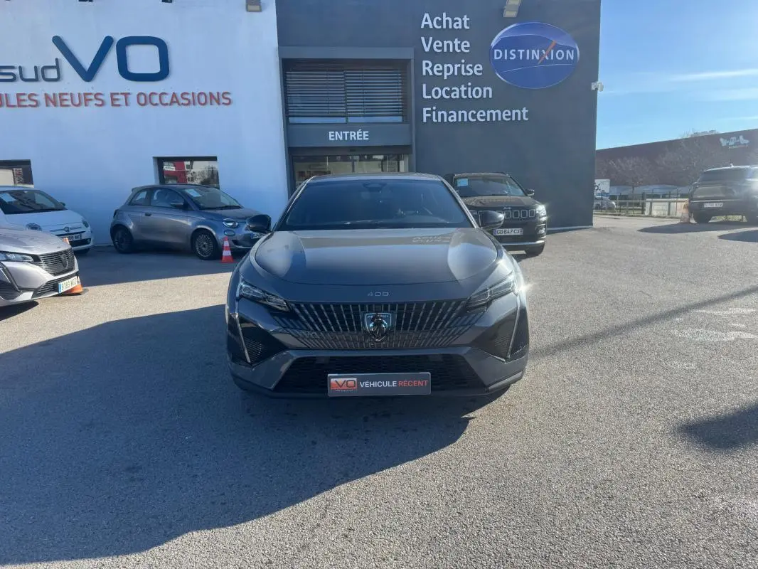 Vue avant d'une Peugeot 408 gris métallisé avec calandre distinctive et jantes alliage 19 pouces, stationnée en extérieur.