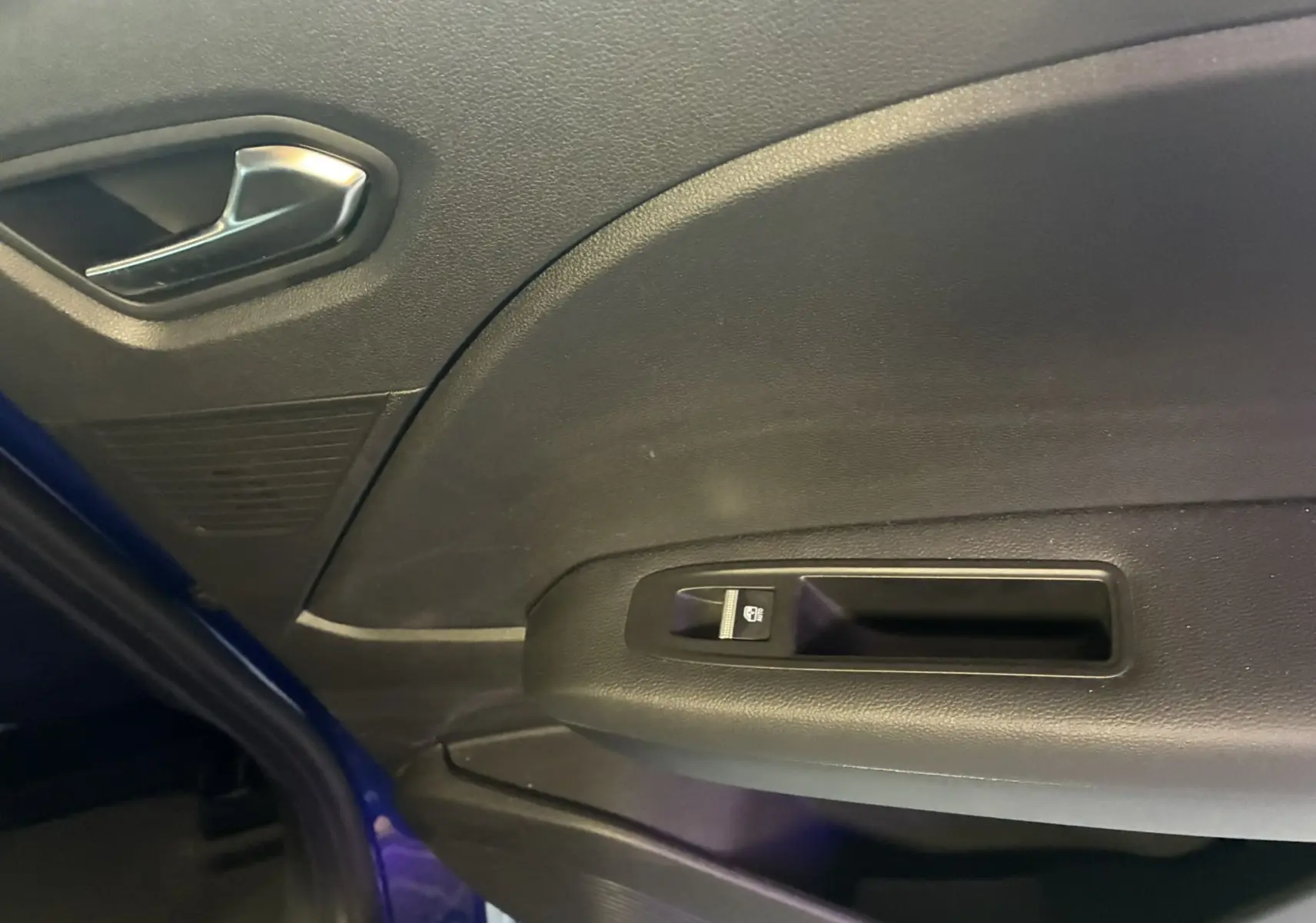 Vue intérieure du panneau de porte côté gauche du Renault Captur bleu 2021, avec commande de lève-vitre électrique.