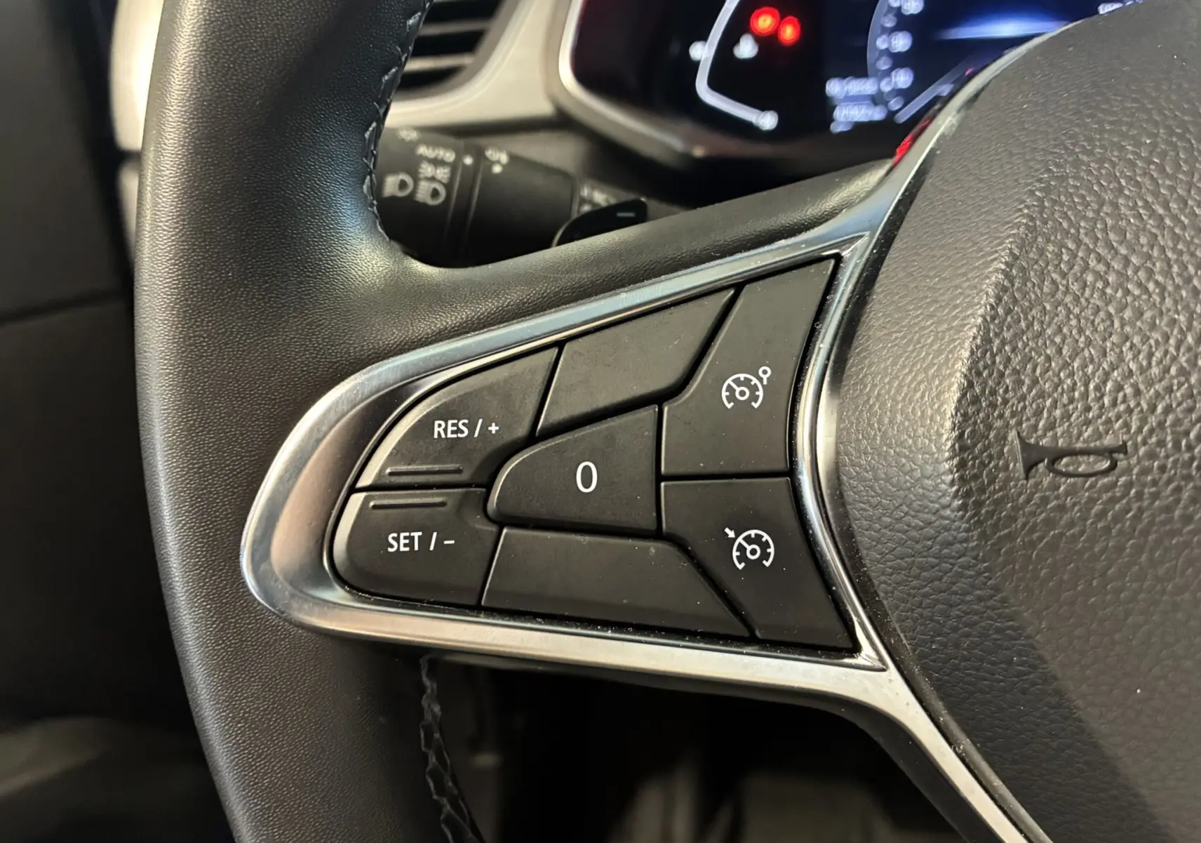Gros plan sur les commandes de régulateur de vitesse au volant noir du Renault Captur 2021, version Intens.