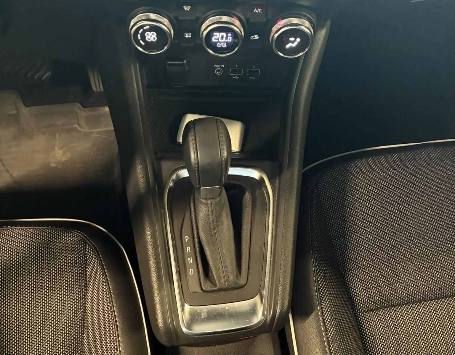Vue plongeante sur la console centrale du Renault Captur bleu 2021, montrant la boîte auto et les commandes de climatisation.